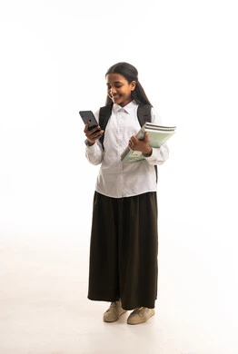 طالبة سعودية تحمل هاتفاً ذكياً وكتباً مدرسية