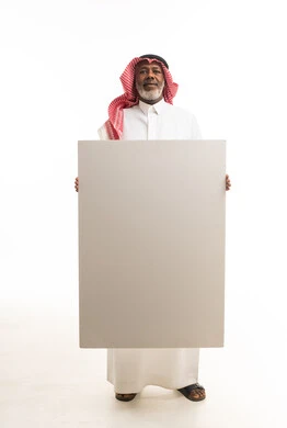 رجل سعودي مسن يحمل لوحة بيضاء فارغة في الاستوديو