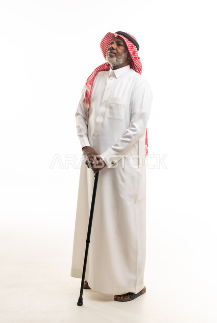 رجل سوداني مسن يرتدي الثوب السعودي التقليدي مع عصا مشي