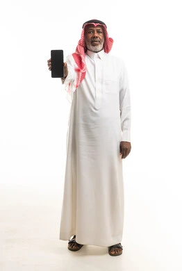رجل سعودي مسن يحمل هاتف ذكي بخلفية بيضاء