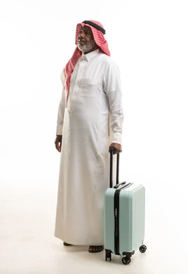 رجل سعودي مع حقيبة سفر على خلفية بيضاء