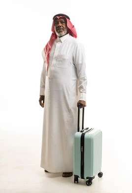 رجل سعودي مع حقيبة سفر على خلفية بيضاء
