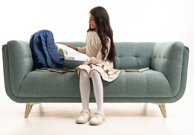 Arab Schoolgirl Reading on Sofa in Studio