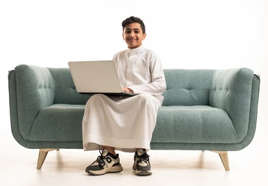 Saudi Boy with Laptop in Traditional White Thobe
