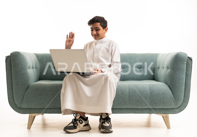 فتى سعودي يستخدم اللابتوب بالثوب التقليدي