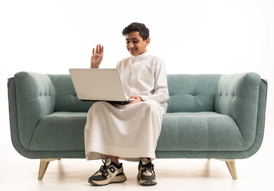 فتى سعودي يستخدم اللابتوب بالثوب التقليدي
