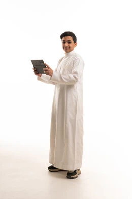 Saudi Boy in White Thobe Holding Digital Tablet