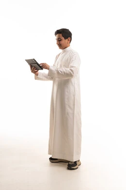 Saudi Boy in Thobe Using Tablet on White Background