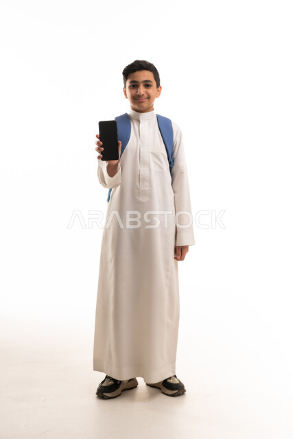 طالب سعودي بالثوب التقليدي يحمل هاتف ذكي