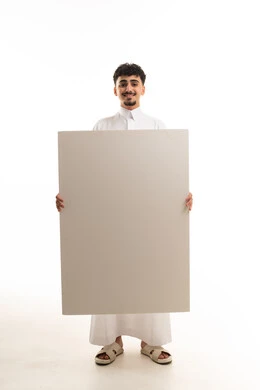 رجل سعودي بالثوب التقليدي يحمل لوحة إعلانية فارغة