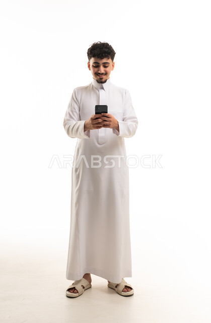 Saudi Man in Traditional Thobe Using Smartphone