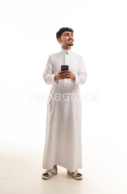 رجل سعودي بالثوب الأبيض يحمل هاتف ذكي