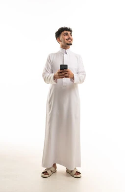 رجل سعودي بالثوب الأبيض يحمل هاتف ذكي