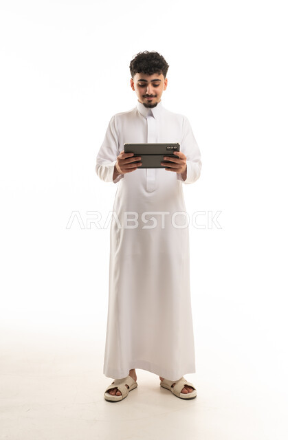 Saudi Man in Traditional Thobe Using Digital Tablet