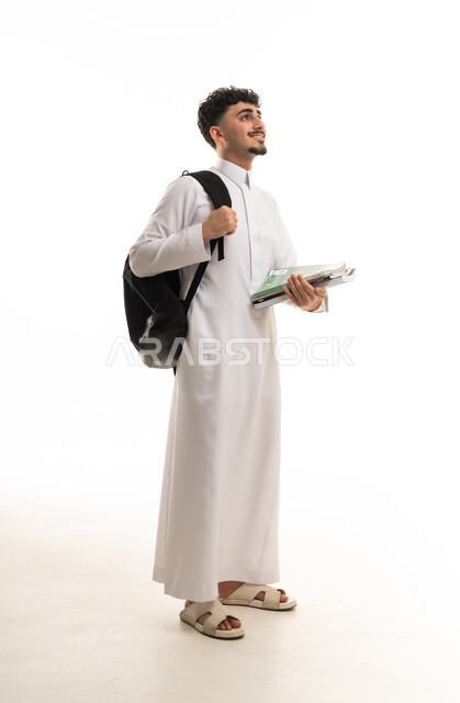 طالب سعودي بالثوب يحمل حقيبة وكتب دراسية