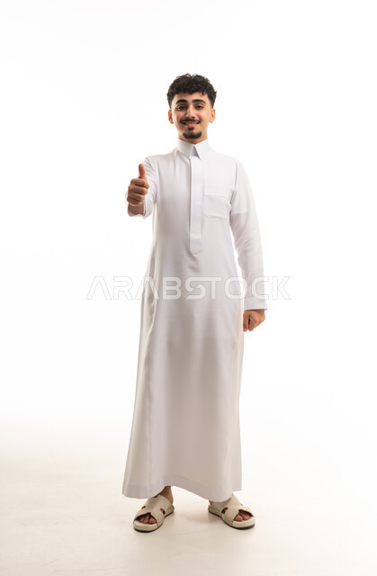 شاب سعودي بالثوب الأبيض يرفع إبهامه للتأييد