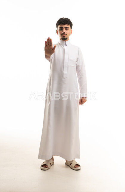 رجل سعودي بالثوب التقليدي يشير بعلامة التوقف
