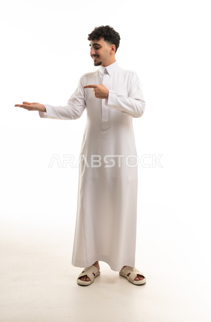 رجل سعودي بالثوب الأبيض يشير بيده على خلفية بيضاء