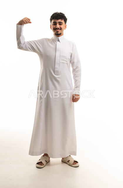 رجل سعودي يرتدي الثوب الأبيض ويستعرض عضلاته
