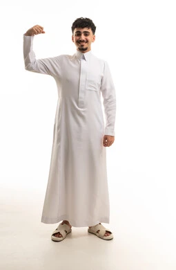رجل سعودي يرتدي الثوب الأبيض ويستعرض عضلاته