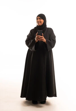 Saudi Woman in Black Abaya Using Smartphone in Studio