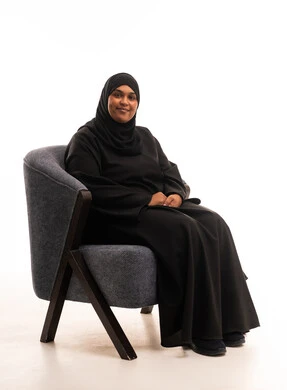 امرأة سعودية بالعباءة السوداء تجلس على كرسي