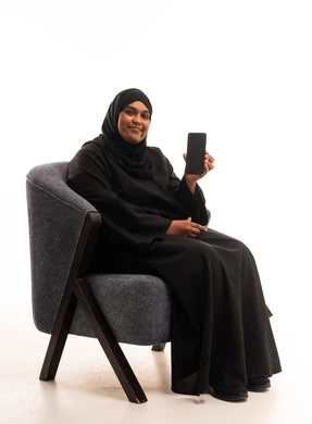 Saudi Woman Holding Smartphone Sitting in Modern Armchair