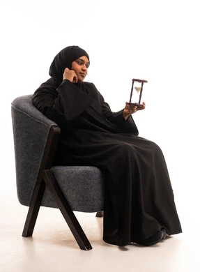 امرأة سعودية تحمل ساعة رملية في الاستوديو