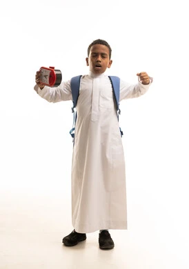 Saudi Schoolboy Yawning with Alarm Clock and Backpack