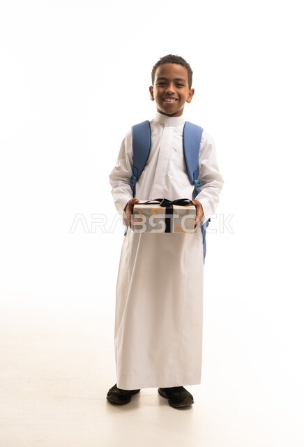 Saudi Boy in Traditional Thobe Holding Gift Box