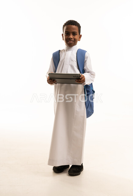 طالب سعودي يحمل جهاز لوحي وحقيبة ظهر