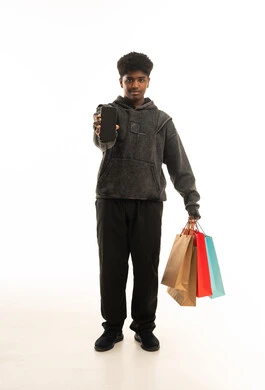 Saudi Man Holding Shopping Bags and Smartphone in Studio