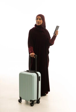 امرأة سعودية بعباءة وحقيبة سفر وهاتف ذكي