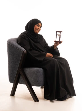 Saudi Woman in Abaya Holding Hourglass in Studio