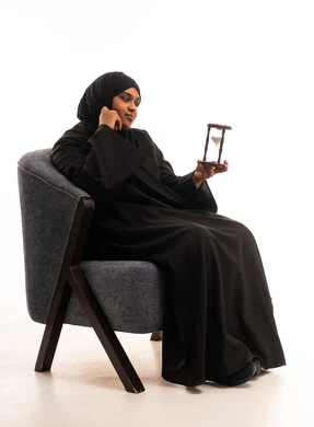 Saudi Woman Holding Hourglass on White Background