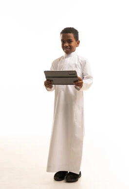 Saudi Boy in Traditional Thobe Holding Tablet