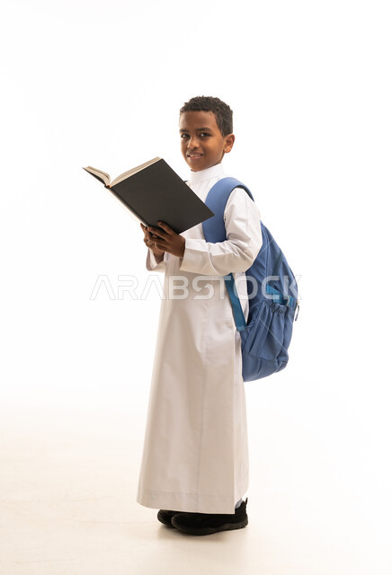 طالب سعودي بالثوب التقليدي يحمل كتابا