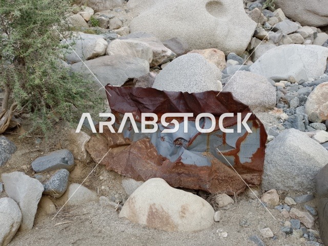 نفايات معدنية صدئة في الطبيعة الصخرية بالباحة