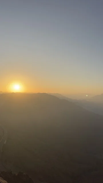 غروب الشمس فوق جبال أبها منظر طبيعي ضبابي