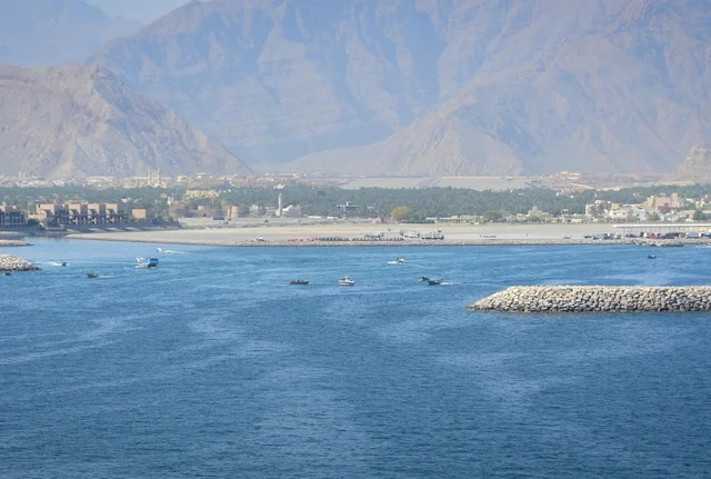 قوارب في المياه الساحلية قرب الجبال في سلطنة عمان