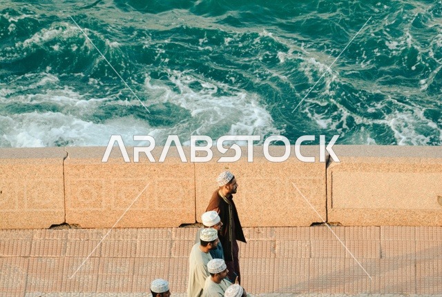 Omani Men Walking Along Sultanate of Oman Seafront