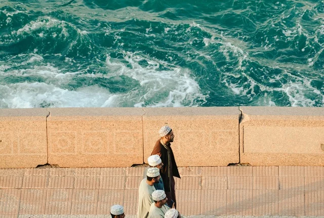 Omani Men Walking Along Sultanate of Oman Seafront