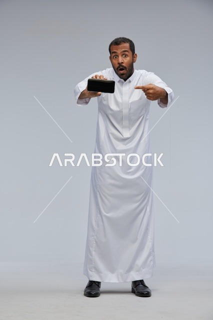 Saudi Man in White Thobe Showing Smartphone Screen