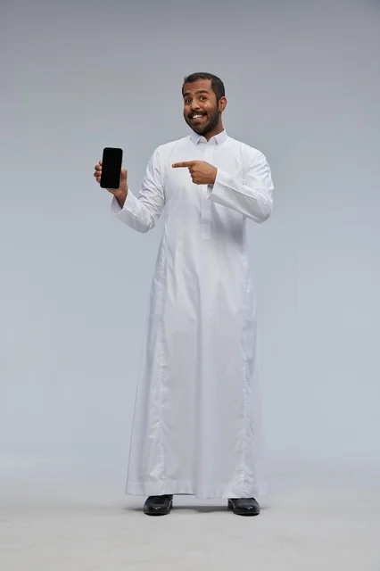 Saudi Man in Thobe Pointing at Blank Smartphone Screen