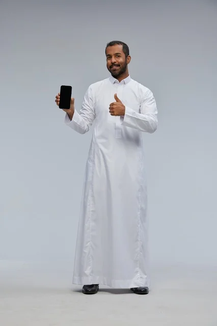 Saudi Man in White Thobe Holding Smartphone Thumbs Up