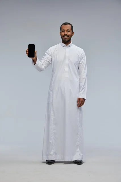 رجل سعودي بالثوب الأبيض يحمل هاتف ذكي