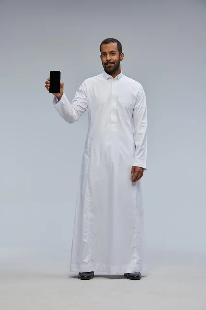 Saudi Man in White Thobe Holding Smartphone Screen