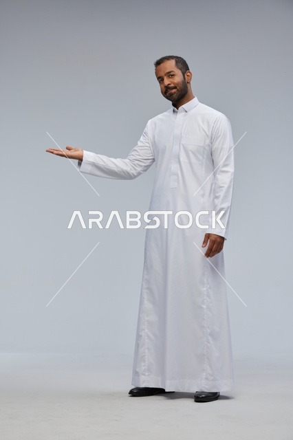 رجل سعودي بالثوب الأبيض يشير بيده في الاستوديو