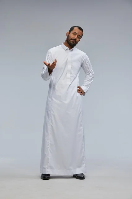 رجل سعودي يرتدي الثوب الأبيض يقف في بورتريه استوديو