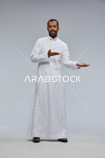رجل سعودي بالثوب الأبيض يشير بيديه في الاستوديو